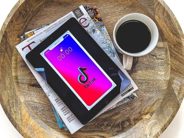 TikTok螢幕上的行動裝置,上面是雜誌,旁邊是一杯咖啡