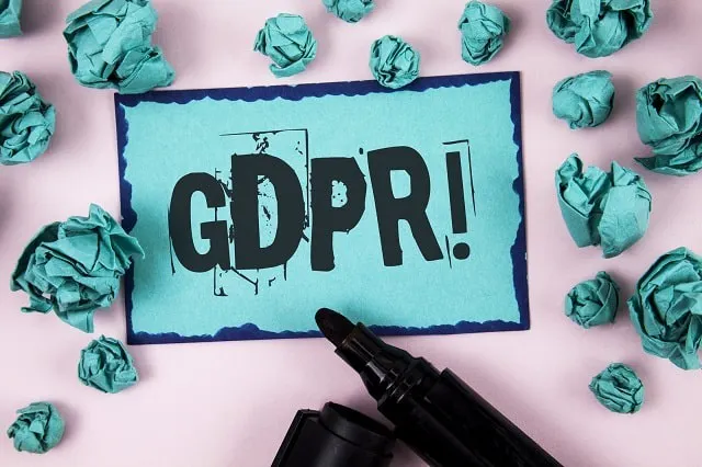 GDPR escrito em notecard rodeado de papéis amassados e um marcador