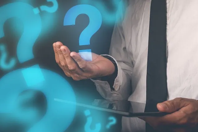 Persona sosteniendo una tableta con el gráfico de un signo de interrogación sobre su mano extendida