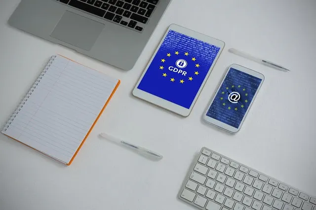 Keyboard, laptop, tablet, and tablet PC and smartphone on a table with GDPR logo and images on devices
