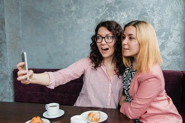 Friends sharing on Snapchat at a coffee shop