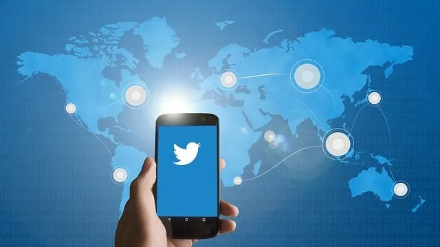 Smartphone mit Twitter-Logo auf einem Kartenhintergrund. Konzept zum Erreichen der Zielgruppe.