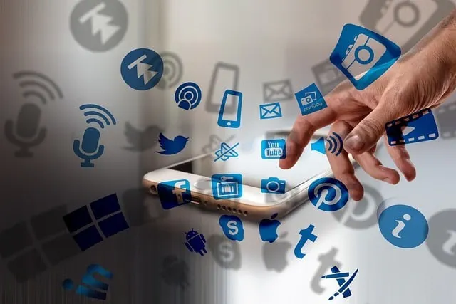 Die Hand berührt ein Smartphone mit eingeblendeten Symbolen für soziale Medien