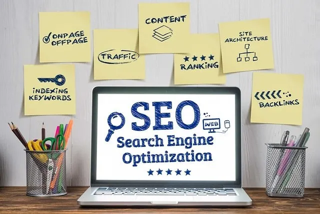 Laptop con SEO sullo schermo circondato da note adesive con vari fattori SEO