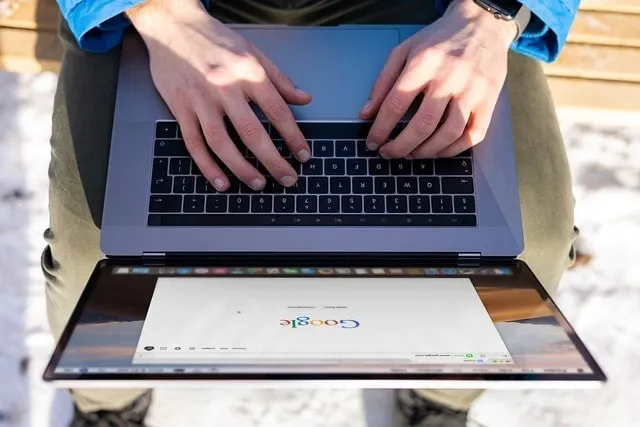 Hands typing on laptop