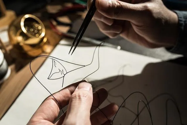 Hands working on a wire sculpture craft