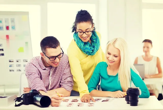 Coworkers in office comparing photos to choose the best Instagram profile photo