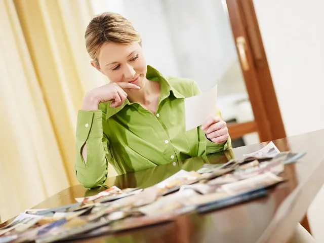 Woman browsing photos on a table to choose the best Instagram profile photo
