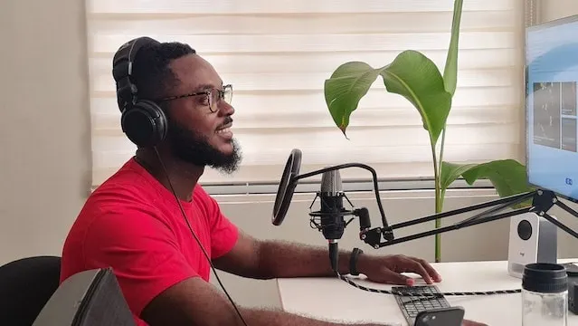 Homme enregistrant un épisode de podcast à un bureau