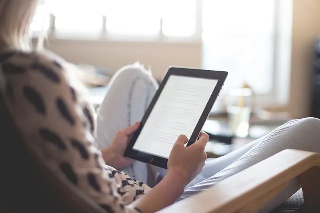 Donna che legge un ebook su un ereader o un Amazon Kindle